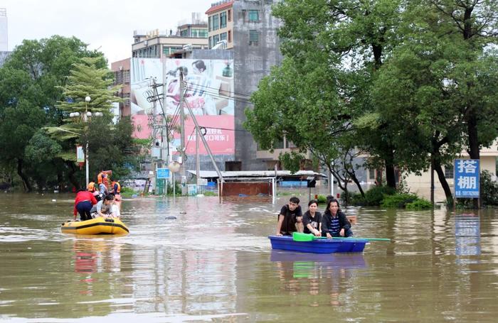 4月21日，广东清远英德市浛洸镇住户在积水的谈路上乘船出行。新华社记者 黄国保 摄