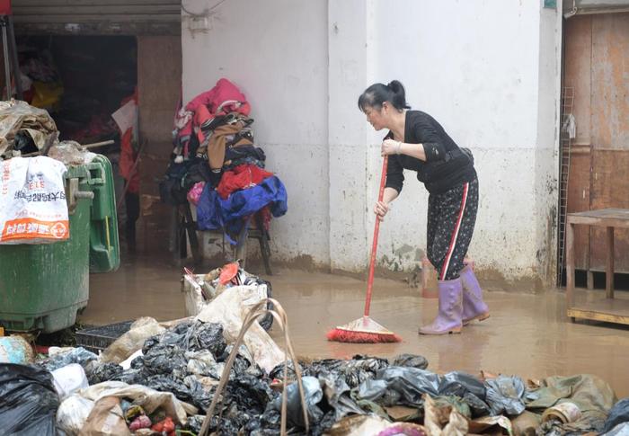 4月21日，洪水事后，广东省韶关市武江区龙归镇的住户在算帐路面。新华社记者 卢汉欣 摄